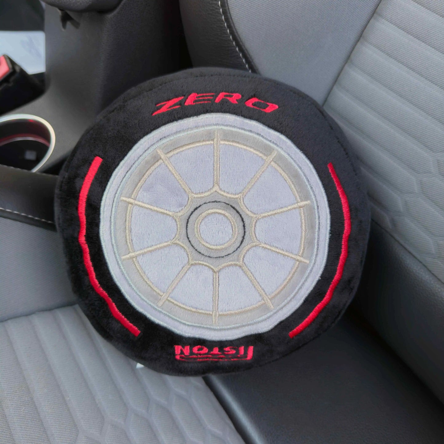 Formula 1 Race Tire Plush Toy cushion pillow shown on car seat