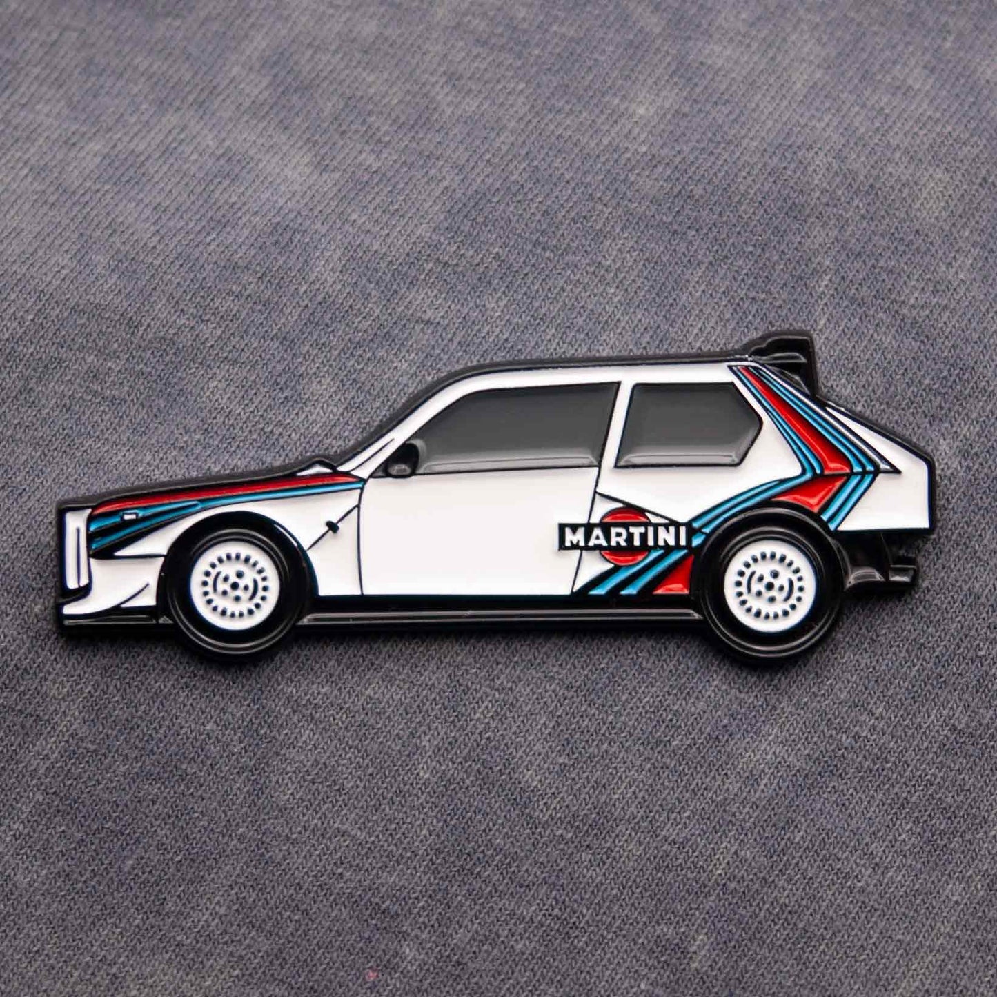 Lancia Delta S4 Rally Car Enamel Pin shown on grey cloth