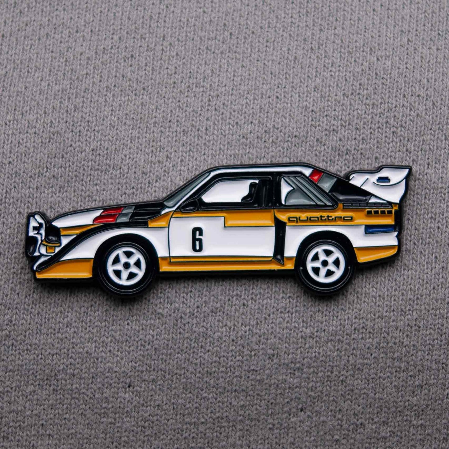 Audi Sport Quattro S1 E2 Rally Car Enamel Pin shown on grey cloth