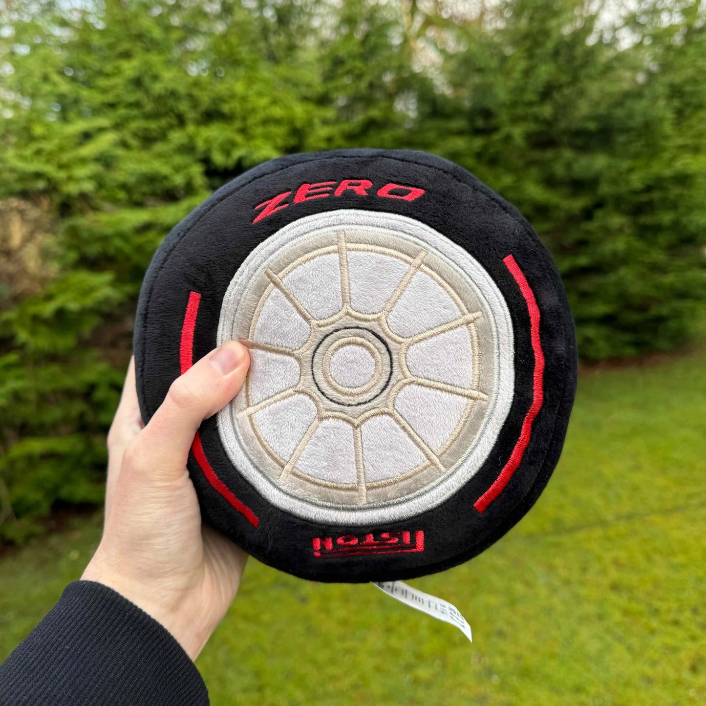 Formula 1 Race Tire Plush Toy cushion pillow shown being held in hand