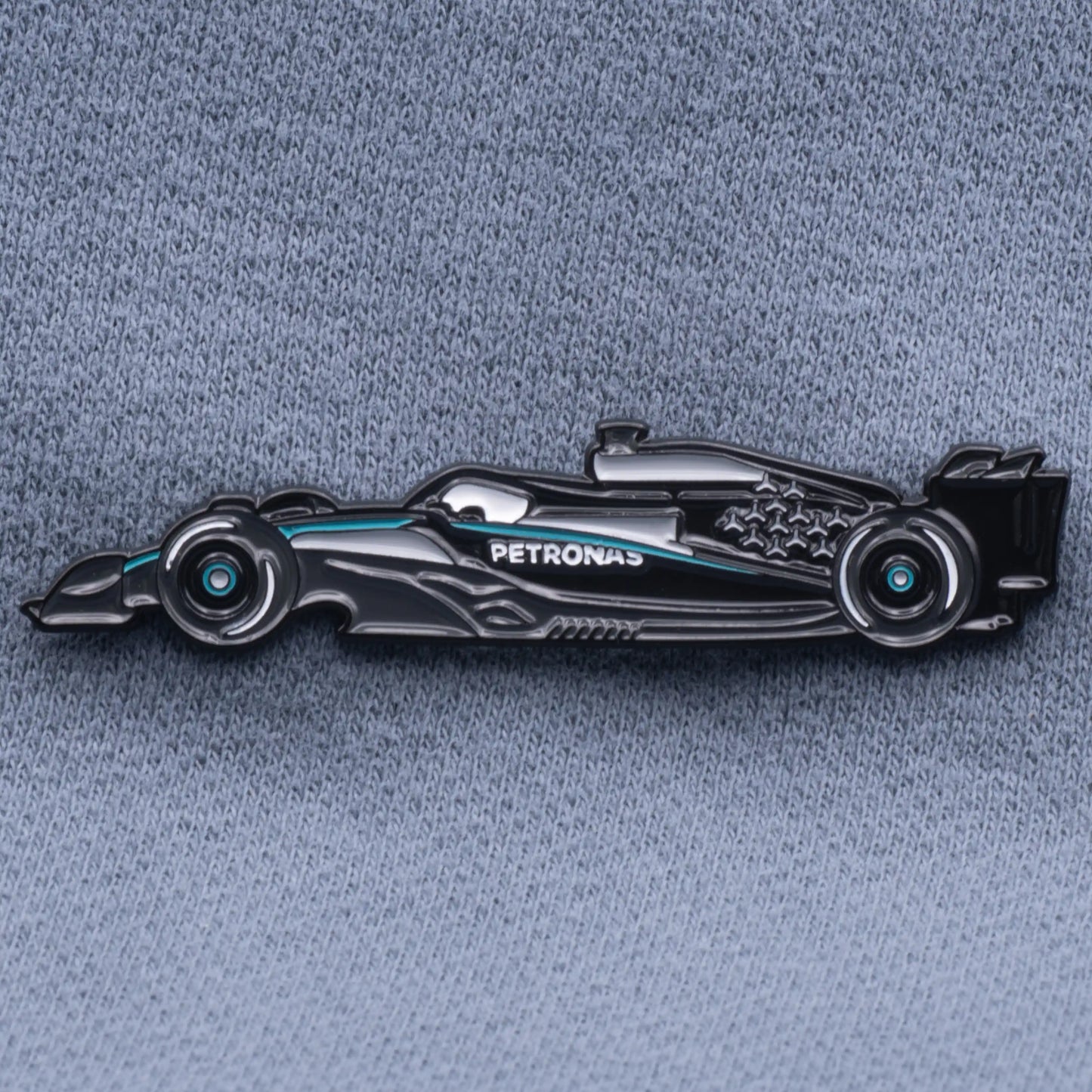 Mercedes W16 Formula One Car Enamel Pin shown on grey cloth