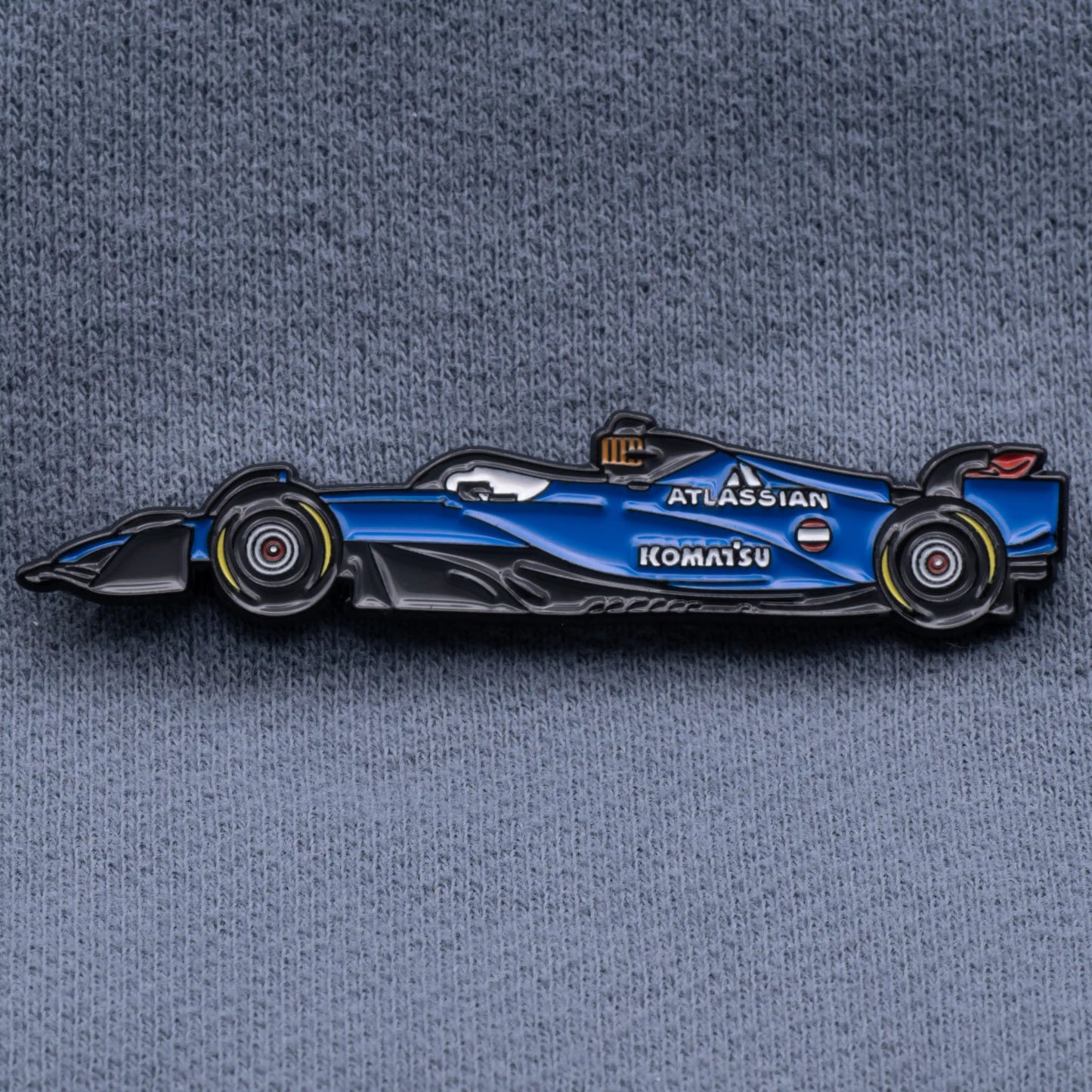 Williams FW47 Formula One Car Enamel Pin shown on grey cloth