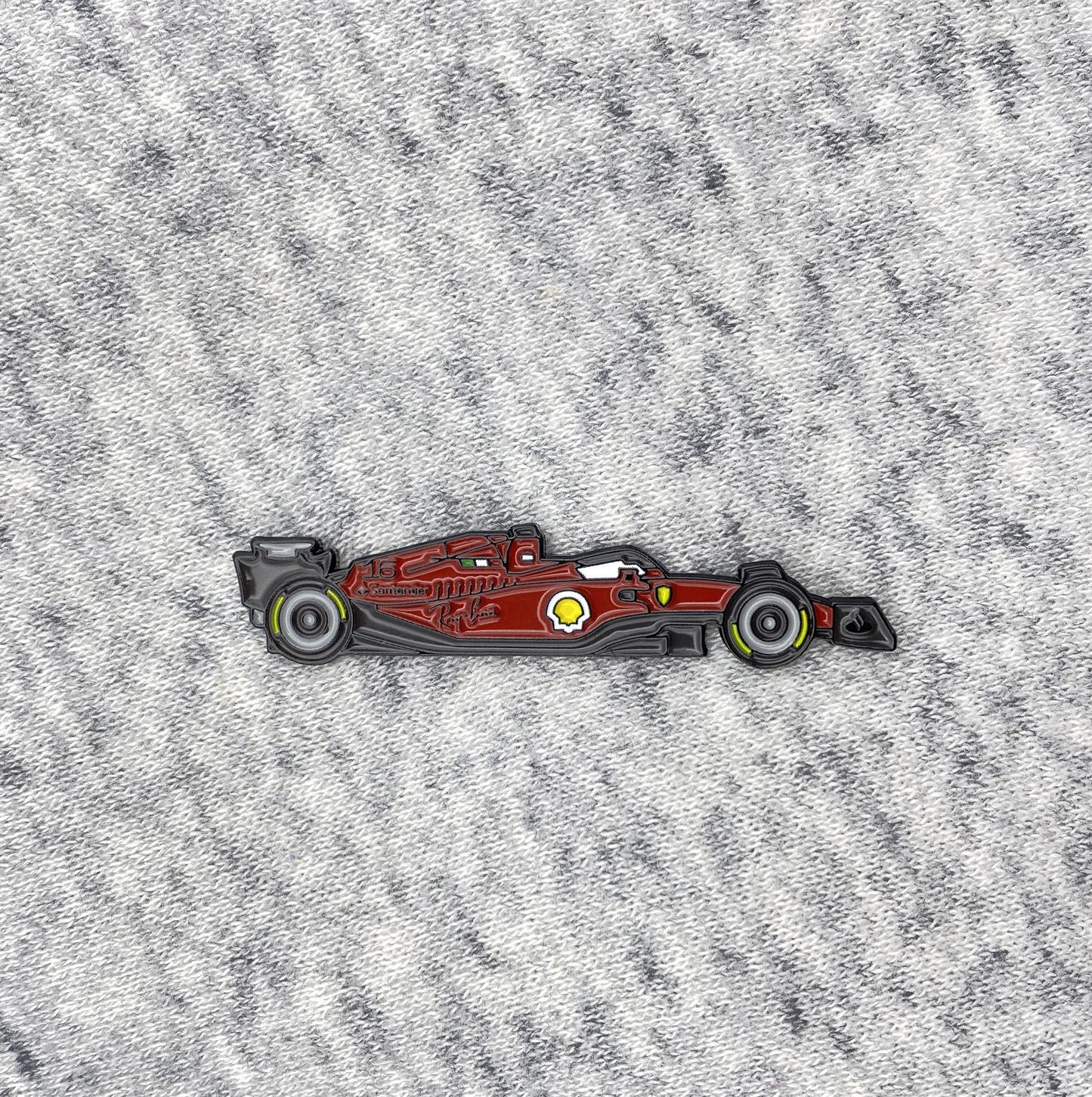 Ferrari F1-75 Formula One Car Enamel Pin shown on cloth