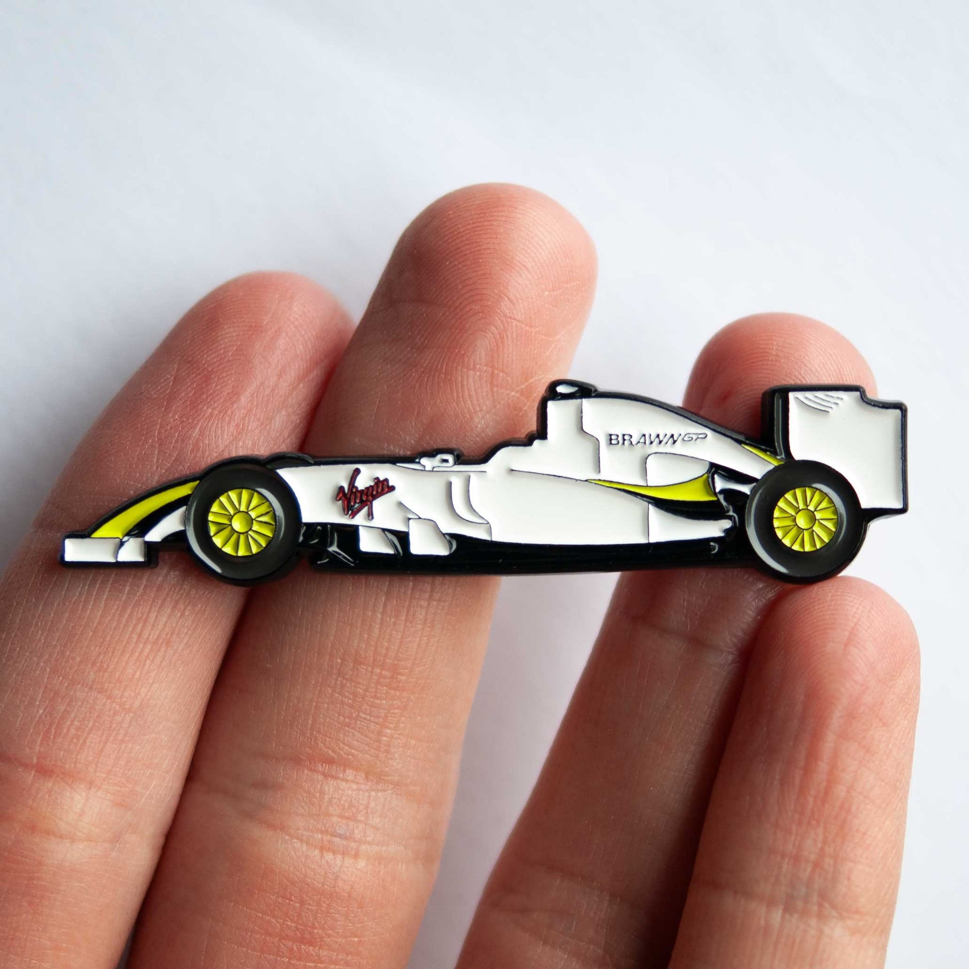 Brawn BGP 001 Formula One Car Enamel Pin shown on hand