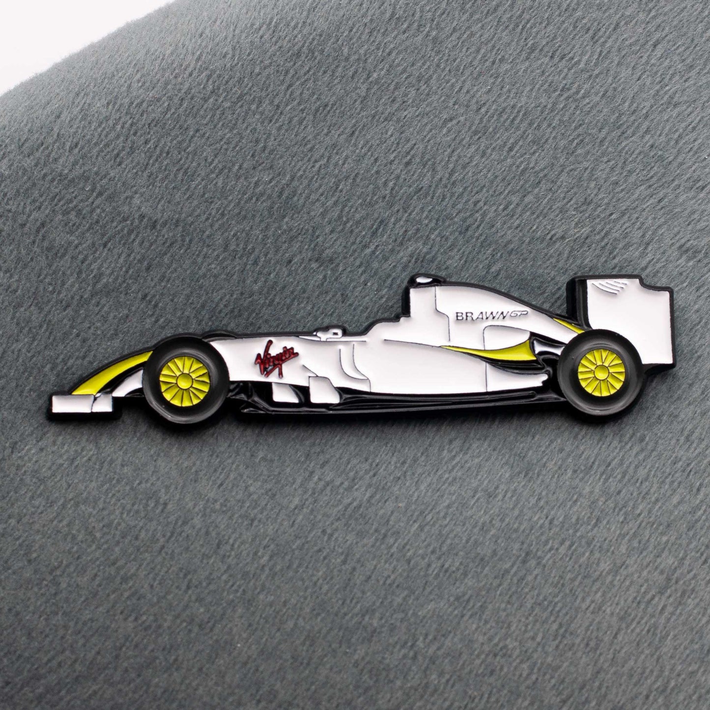Brawn BGP 001 Formula One Car Enamel Pin shown on grey cloth