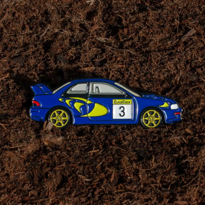 Subaru Impreza WRC98 Rally Car Enamel Pin shown on dirt background