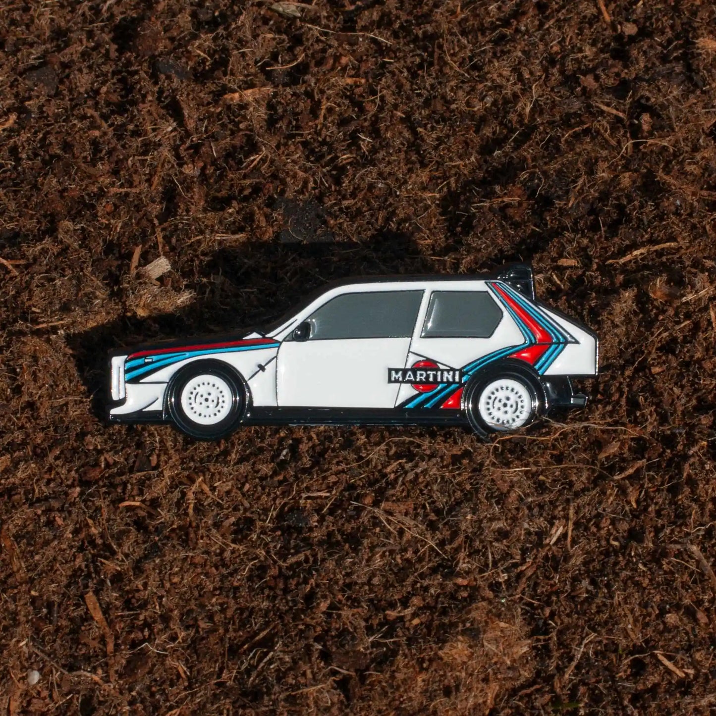 Lancia Delta S4 Rally Car Enamel Pin shown on dirt background