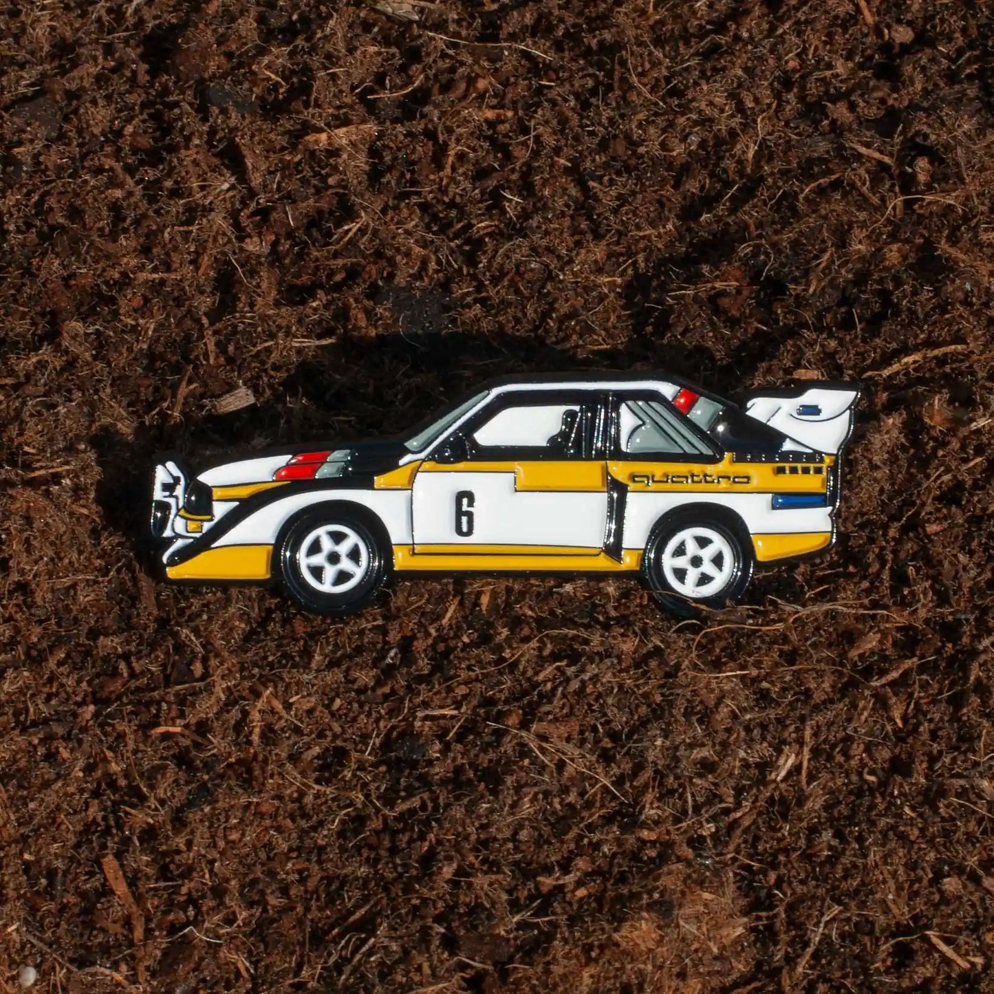 Audi Sport Quattro S1 E2 Rally Car Enamel Pin shown on dirt background