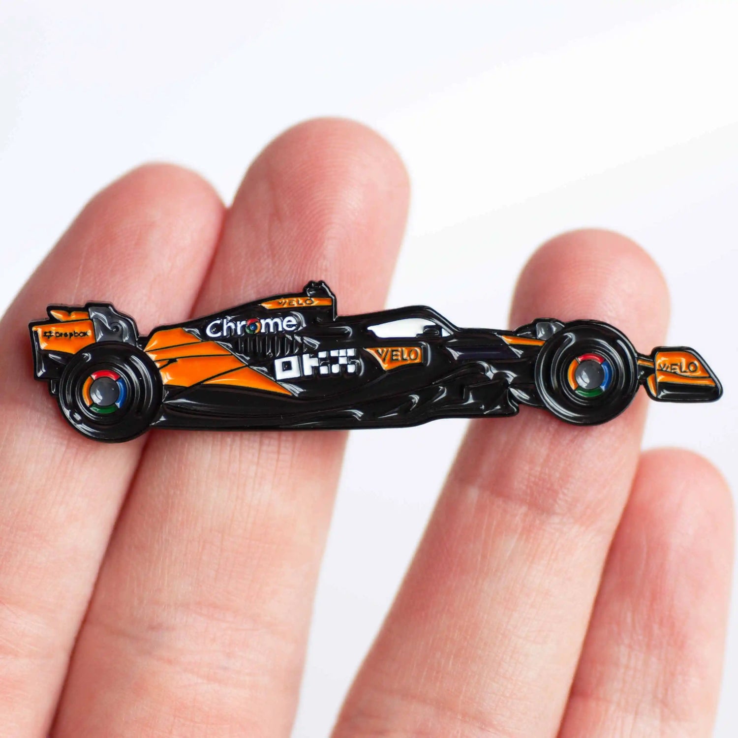 McLaren MCL38 Formula One Car Enamel Pin Badge shown on hand