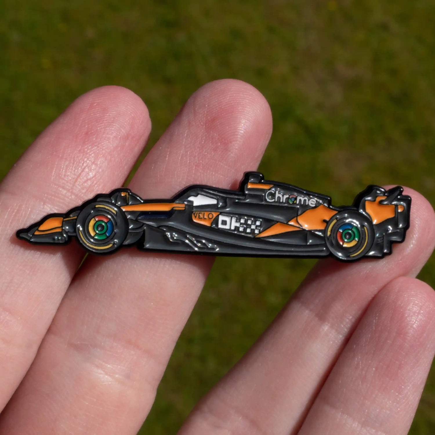 McLaren MCL39 Formula One Car Enamel Pin shown on hand