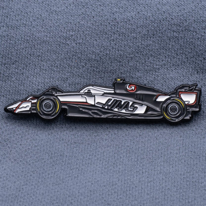 Haas VF-25 Formula One Car Enamel Pin shown on grey cloth