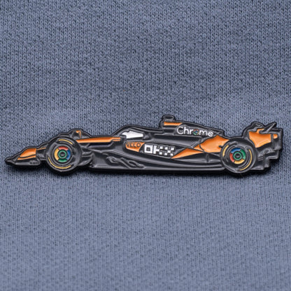 McLaren MCL39 Formula One Car Enamel Pin shown on grey cloth