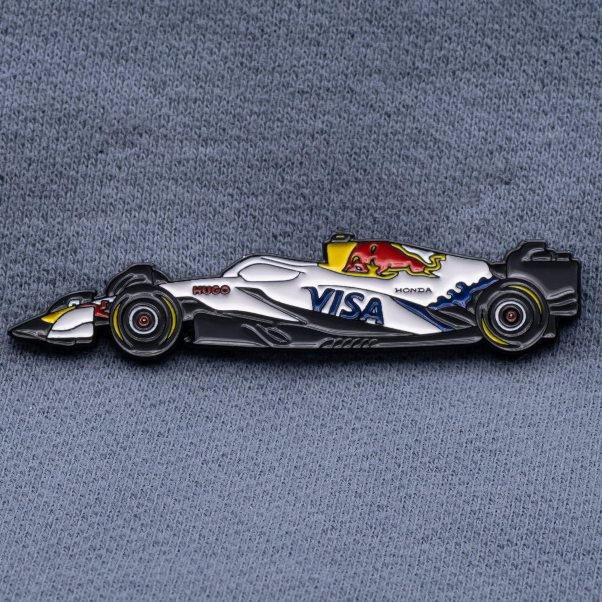 Racing Bulls VCARB 02 Formula One Car Enamel Pin shown on grey cloth