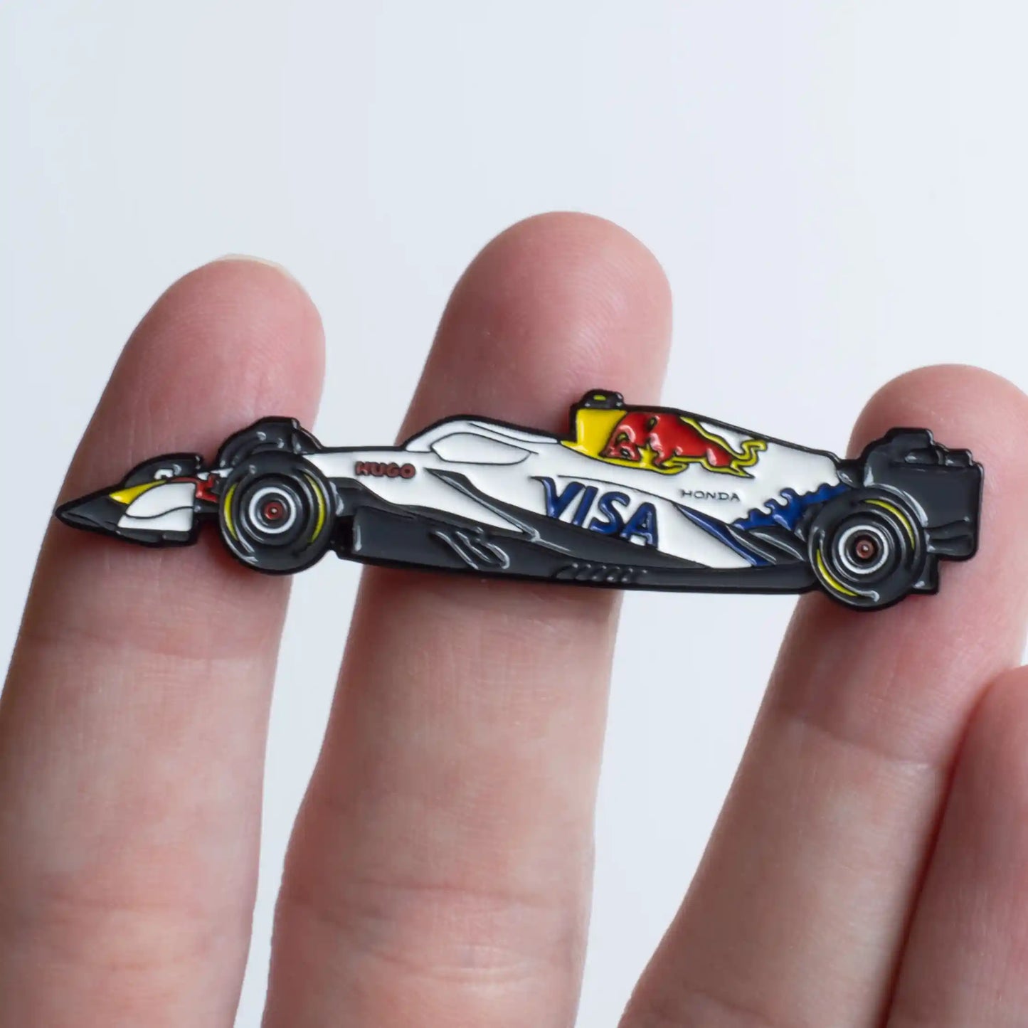 Racing Bulls VCARB 02 Formula One Car Enamel Pin shown on hand