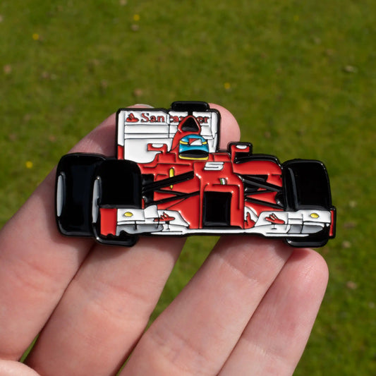 Fernando Alonso's F2012 Formula One Car Enamel Pin shown on hand
