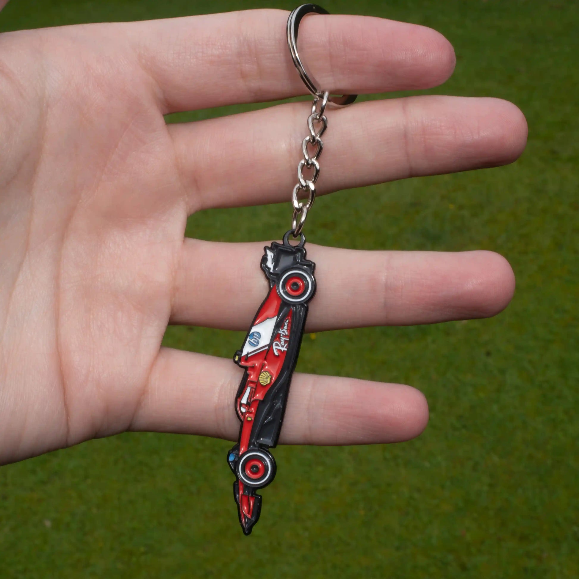 Ferrari SF-25 Formula One Car Enamel Keychain shown on hand