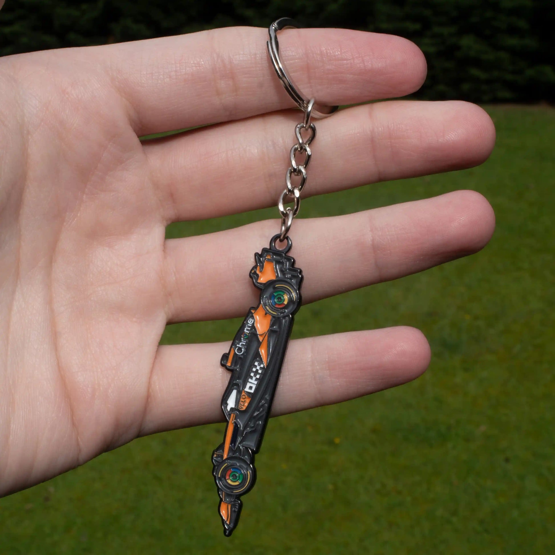 McLaren MCL39 Formula One Car Enamel Keychain shown on hand
