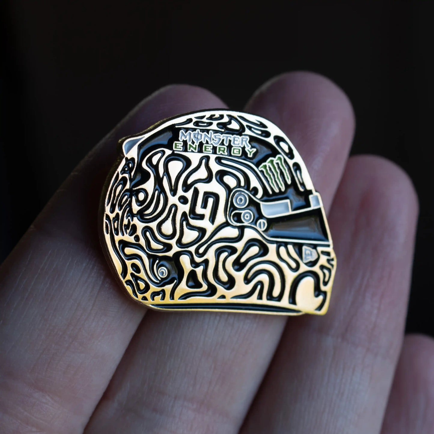 Lando Norris Golden Champion Helmet Enamel Pin on hand in direct sunlight