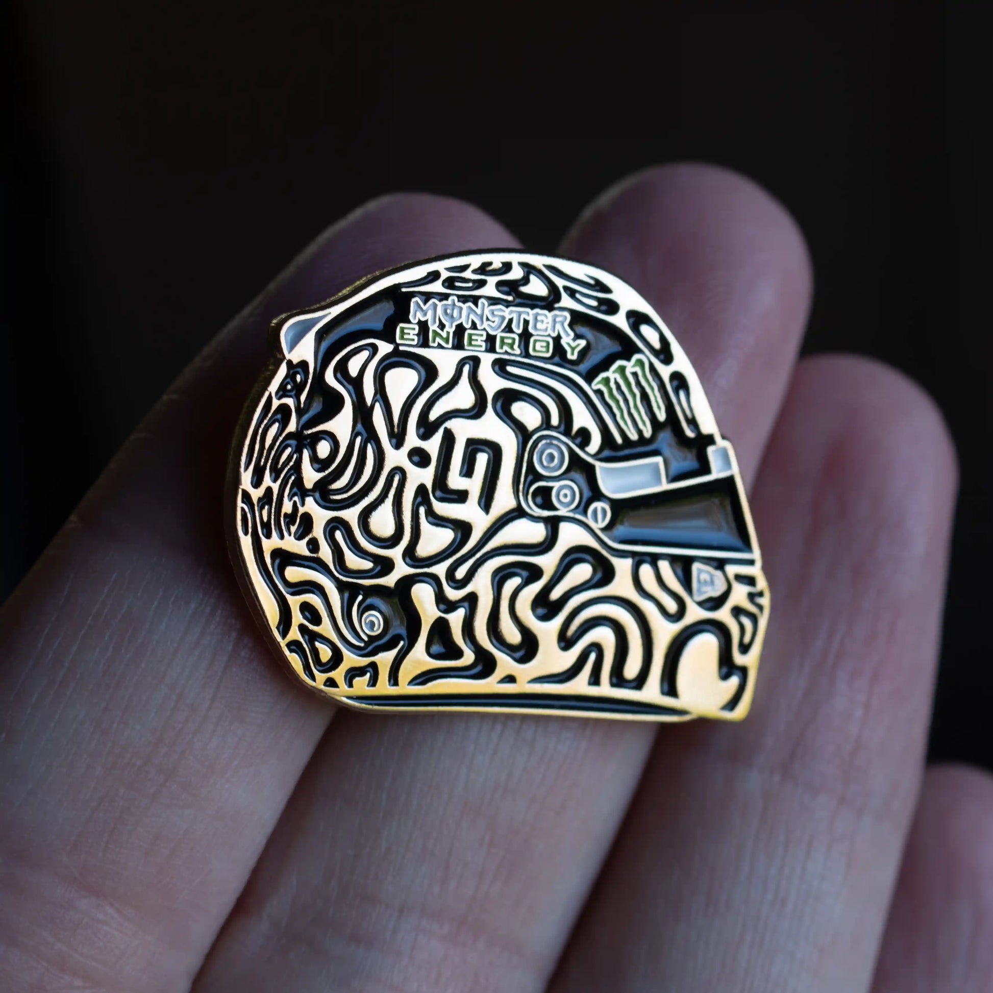 Lando Norris Golden Champion Helmet Enamel Pin on hand in direct sunlight